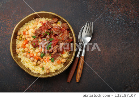 Moroccan couscous with tender meat and chickpea stew in rustic bow top view, Maghreb cuisine, space for text 132187107