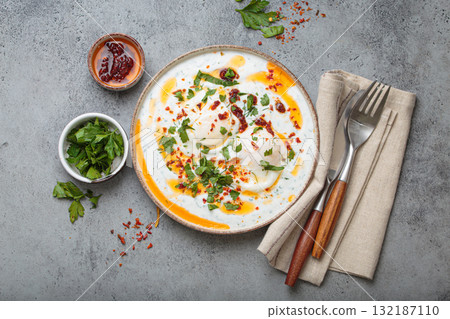 Turkish eggs cilbir, Middle Eastern style breakfast on grey concrete background table top view 132187110