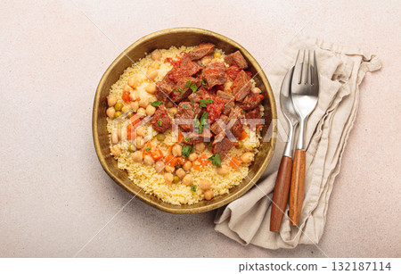 Moroccan couscous with tender meat and chickpea stew in rustic bow top view, Maghreb cuisine 132187114