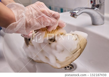 The Process of Cleaning Your Sneakers Using Foam and Gloves in a Sink for Best Results 132187430