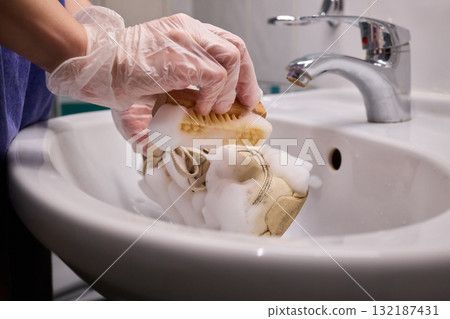 The Process of Cleaning Your Sneakers Using Foam and Gloves in a Sink for Best Results 132187431