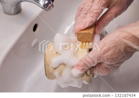 The Process of Cleaning Your Sneakers Using Foam and Gloves in a Sink for Best Results 132187434