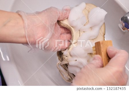 The Process of Cleaning Your Sneakers Using Foam and Gloves in a Sink for Best Results 132187435