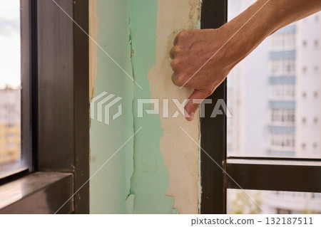 Conducting a Thorough Hand Inspection of Wall Damage in a Modern Apartment Space Conducting a Thorough Hand Inspection of Wall Damage in a Modern Apartment Space 132187511