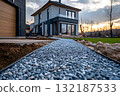 New gravel garden walkway with clean edging leading to modern house at sunset 132187533