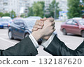 Handshake in the city while cars pass by in the background. 132187620