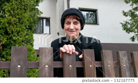 A smiling elderly woman in a black coat and knitted hat A smiling elderly woman in a black coat and knitted hat 132187775