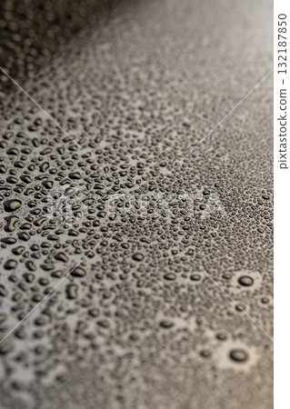 Black glass surface in water droplets, wet mirrored black glass in a large number of water drops, close up 132187850