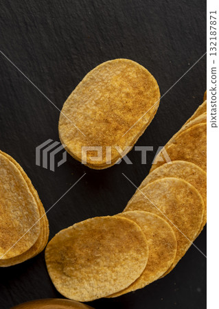 crispy chips fried in oil and sprinkled with spices of dried red sweet pepper, a large number of delicious salty sweet pepper-flavored chips with aromatic spices crispy chips fried in oil and sprinkled with spices of dried red sweet pepper, a large number of delicious salty sweet pepper-flavored chips with aromatic spices 132187871