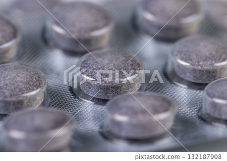 cylindrical purple tablets made from natural ingredients packed in a blister , whole purple tablets packed in a plastic blister with the addition of blueberry extract and other ingredients 132187908