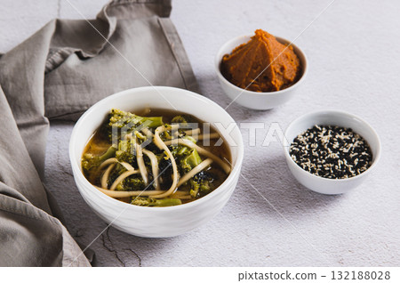Asian broccoli noodle miso soup in a bowl on the table Asian broccoli noodle miso soup in a bowl on the table 132188028