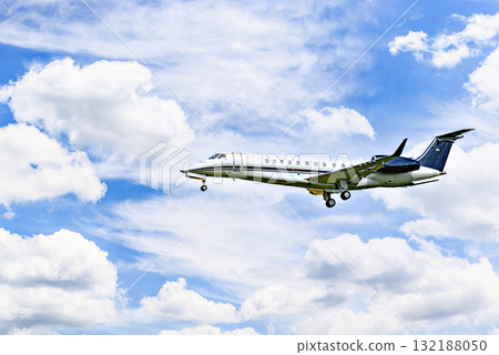 Private business plane flying under blue sky with white clouds 132188050