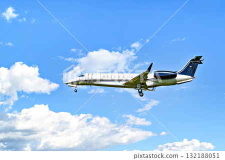 Private business plane flying under blue sky with white clouds Private business plane flying under blue sky with white clouds 132188051