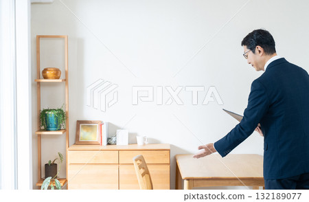 A man in a suit checking furniture A man in a suit checking furniture 132189077