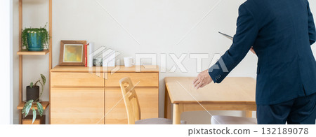 一名西裝革履的男子正在檢查家具 132189078
