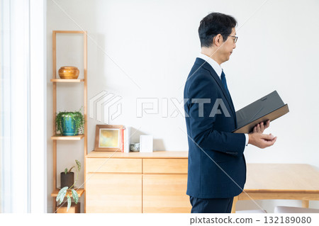 一名西裝革履的男子正在檢查家具 132189080