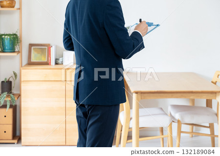 一名西裝革履的男子正在檢查家具 132189084