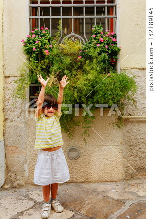 small happy girl in big sunglasses posing next to old building outdoors small happy girl in big sunglasses posing next to old building outdoors 132189145
