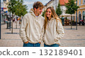A man and a woman standing next to each other on a city street 132189401