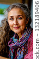 A woman with long curly hair wearing a colorful scarf 132189406