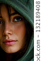 A close up of a woman with a green hoodie on her head 132189408