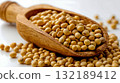 A wooden spoon filled with soy beans on a white surface 132189412