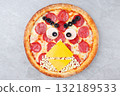 Creative Angry Birds Inspired Pepperoni Pizza with Cheese Beak, Ham and Olive Eyes, Fun Face Made from Food on Gray Background 132189533