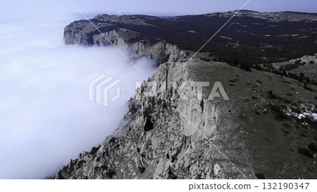 Aerial view flying over rocky mountain cliffs above clouds. Media Aerial view flying over rocky mountain cliffs above clouds. Media 132190347