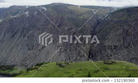 Waterfall cascading down rocky mountainside in chulyshman valley. Media 132190360