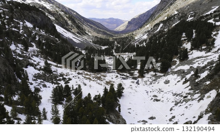 Snowy valley panning across mountain range with pine trees. Media 132190494