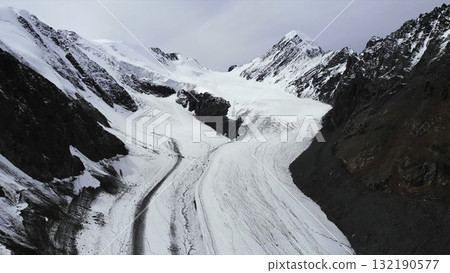 Majestic mountain glacier winds through snowy peaks. Media 132190577
