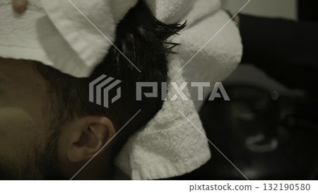 Hairdresser drying man's hair with white towel. Clip 132190580