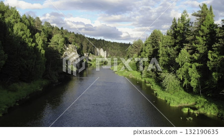 Serene river flows through lush green forest landscape Serene river flows through lush green forest landscape 132190635