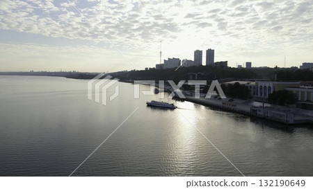 Passenger ferry navigating river at sunrise near city coastline. Clip 132190649