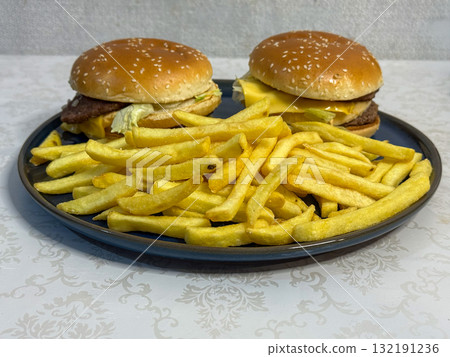 Two Cheeseburgers and French Fries on a Plate Two Cheeseburgers and French Fries on a Plate 132191236