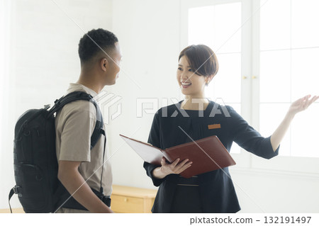 一名酒店女服務生向一名外國男子解釋事情 132191497