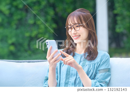 A woman watching a smartphone A woman watching a smartphone 132192143