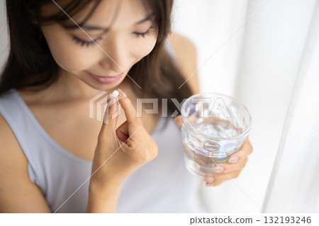 一位女士手中拿著的補充劑藥丸的特寫 132193246