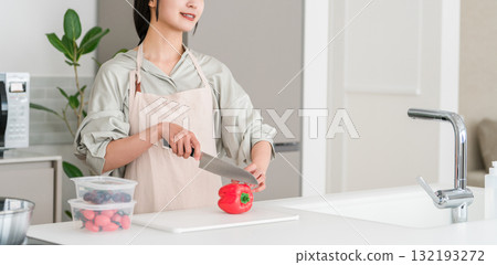 Young Asian woman in an apron cooking in the kitchen 132193272