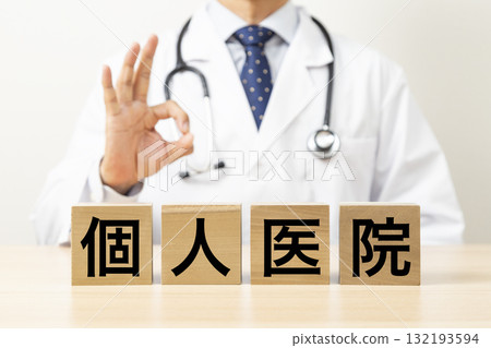 A block with the words "Private Clinic" written on it and a doctor making an OK sign A block with the words "Private Clinic" written on it and a doctor making an OK sign 132193594