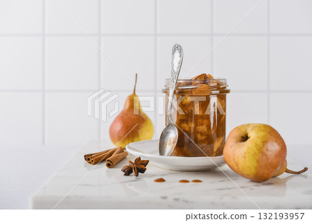 Pear jam in a glass jar with ripe pears 132193957
