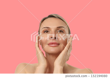 Woman gently massaging cream into her skin for hydration Woman gently massaging cream into her skin for hydration 132194080