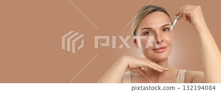 Female applying serum for skincare to enhance her complexion Female applying serum for skincare to enhance her complexion 132194084