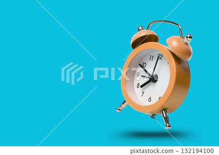 Orange alarm clock displaying time on a blue background 132194100