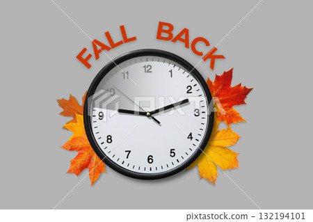 Clock surrounded by decorative autumn leaves on gray background 132194101