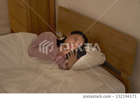 看在蒲團的婦女智能手機 132194171