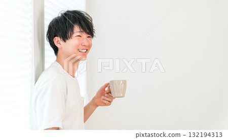 亞洲年輕男子在窗邊喝熱飲、茶、咖啡 132194313