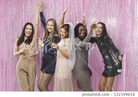 Happy girlfriends celebrating wedding of young bride in white bridal dress at bachelorette party Happy girlfriends celebrating wedding of young bride in white bridal dress at bachelorette party 132194618
