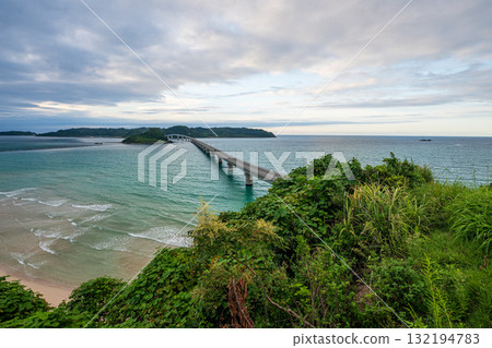 Waves crashing on the beautiful sandy beach of Tsunoshima and the Tsunoshima Bridge 132194783