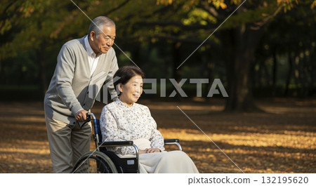 A husband taking a walk with his wife in a wheelchair A husband taking a walk with his wife in a wheelchair 132195620